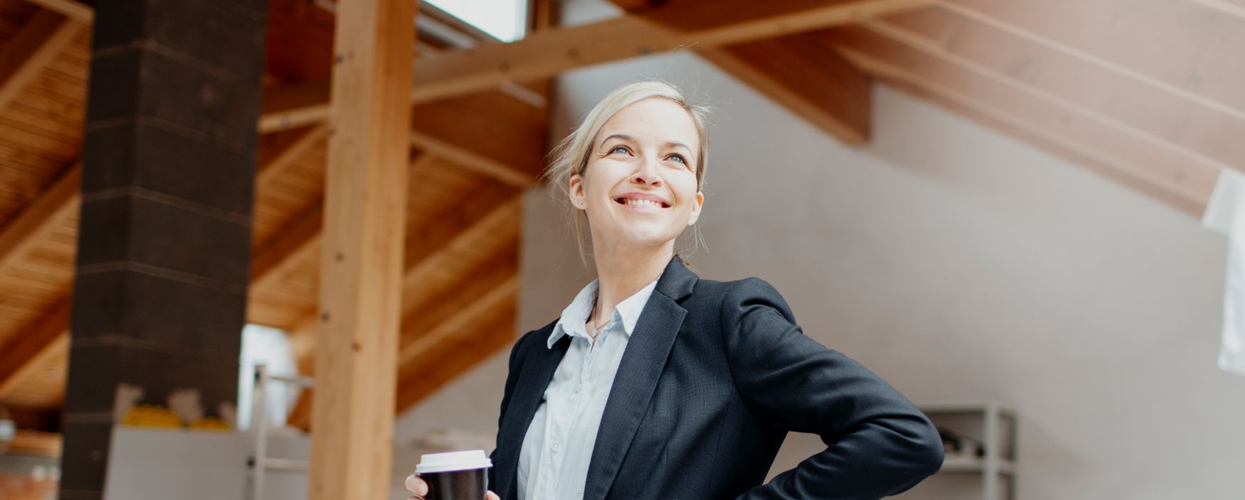 Frau in Blazer mit Kaffeebecher