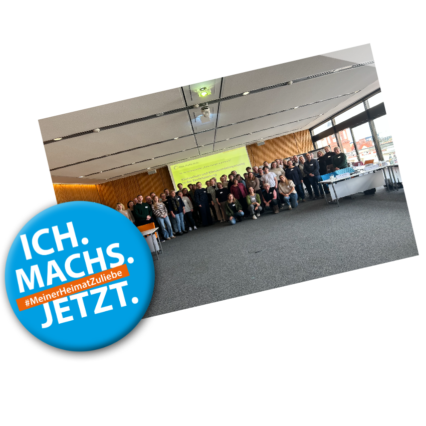 Badge mit Text: "Ich machs jetzt #MeinerHeimatZuliebe" vor einem Bild von einer Gruppe von Klimaschutzmanagerinnen und Klimaschutzmanagern